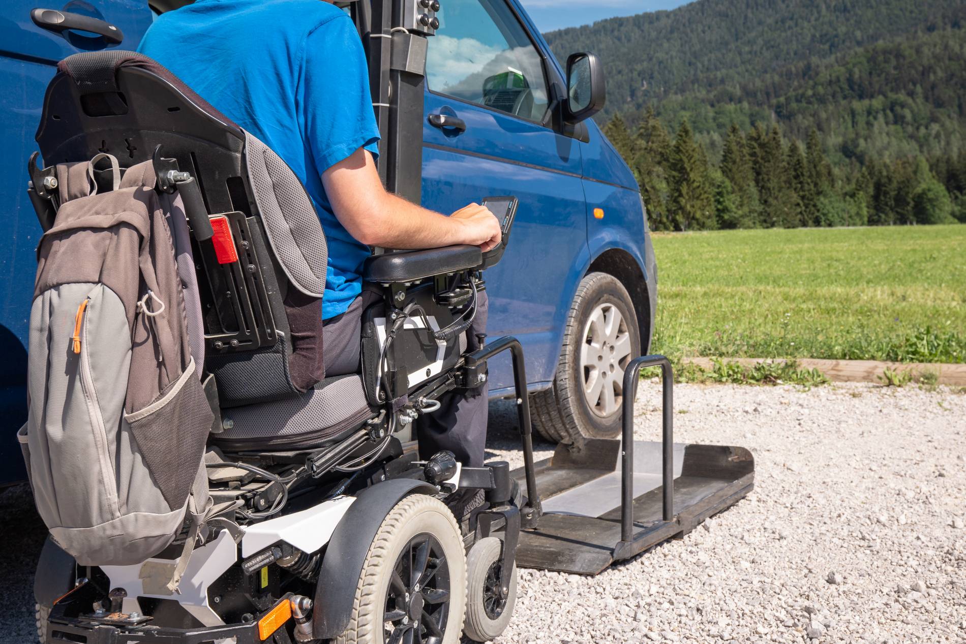 Personne en fauteuil électrique accédant à un véhicule TPMR